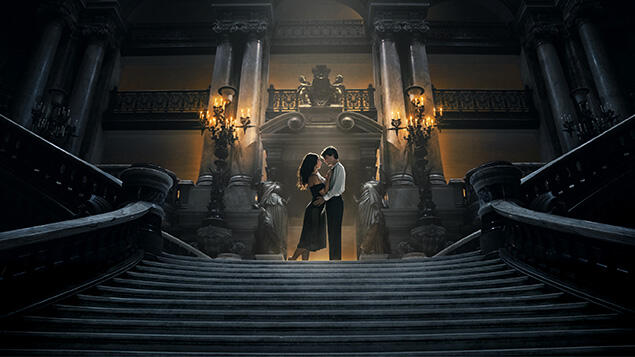 Oficiální vizuál filmu Fantom opery: dvojice na schodišti operní budovy.